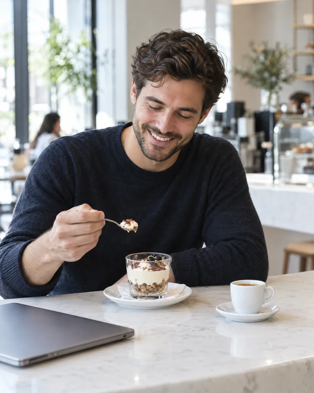 Kafe tezgâhında porsiyonluk tatlısını yiyen bir müşteri